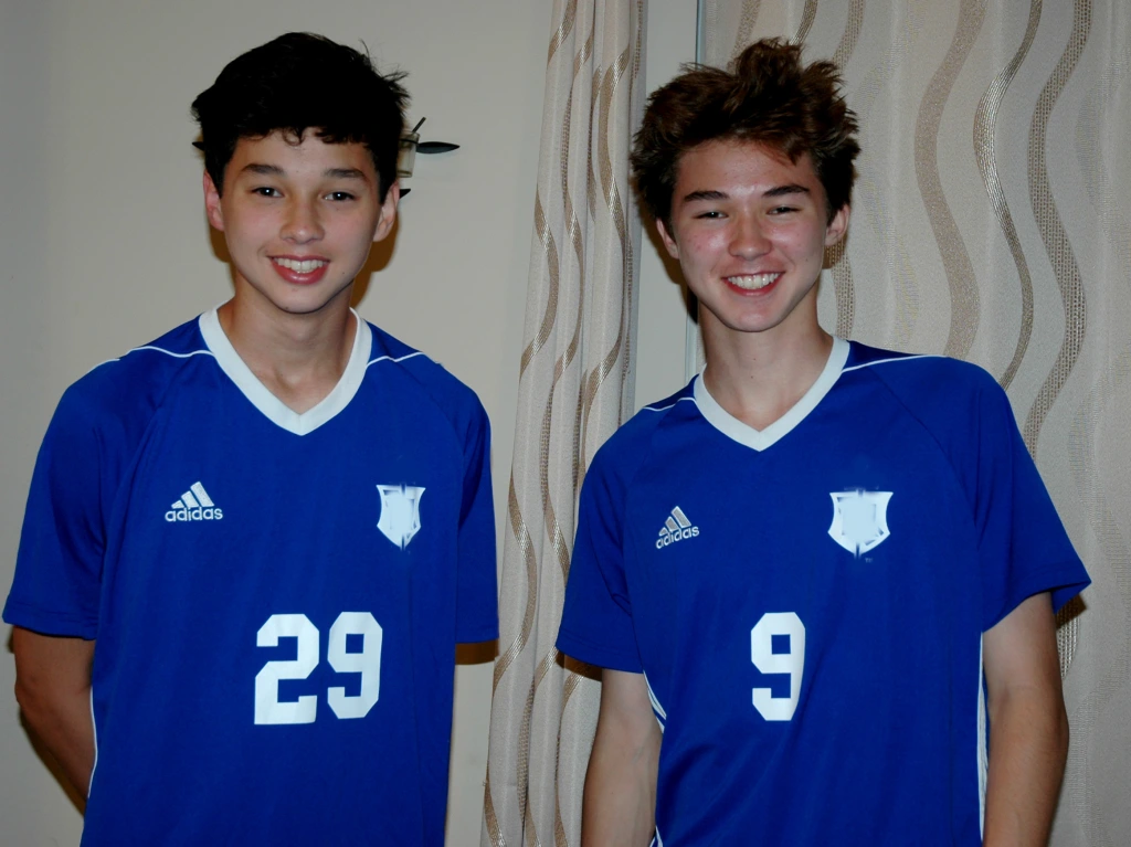  Keaton (left, age 15) and Kendrick (right, age 17) in their high school jerseys in 2018. The big smiles and messy hair suggest the picture was taken after a winning game.